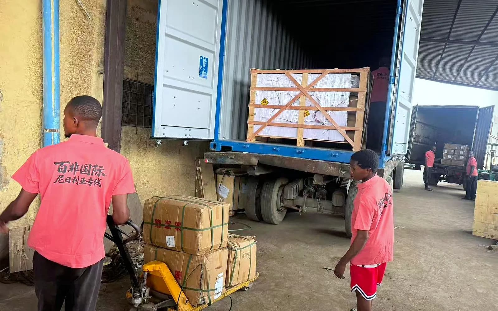 فريقنا في نيجيريا بزي Best Africa Logistics يفرّغ البضائع من حاوية برافعة يدوية لتوصيلها