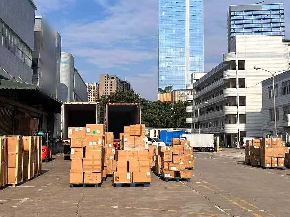 ساحة مستودع شنتشن مع منصات بضائع مرتبة وحاويتين قيد التحميل
